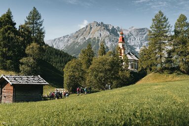 Eine Gruppe wandert an der Kirche in Obernberg vorbei | © TVB Wipptal | Johannes Bitter