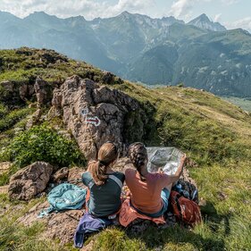 Zwei Frauen sitzen am Berg und studieren die Wanderkarte | © TVB Wipptal