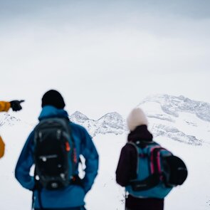 Drei Skitourengeher stehen vor einem verschneiten Bergmassiv | © TVB Wipptal | Johannes Bitter
