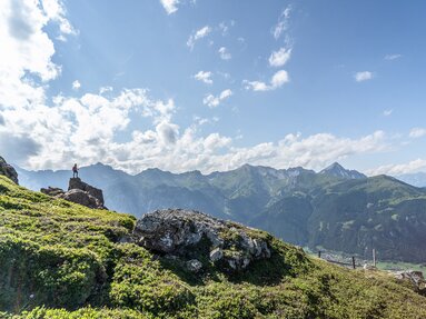 Wanderer auf einem Felsen unterhalb des Nösslachjochs in Steinach mit Blick ins Gschnitztal hinunter | © TVB Wipptal - Helena Beermeister