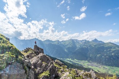 Wandelaars op een rots onder het Nösslachjoch in Steinach met uitzicht op het Gschnitztal | © TVB Wipptal - Helena Beermeister