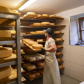 Thomas Almberger wendet den Almkäse im Käsekeller auf der Steineralm in Obernberg | © TVB Wipptal / Almis Berghotel