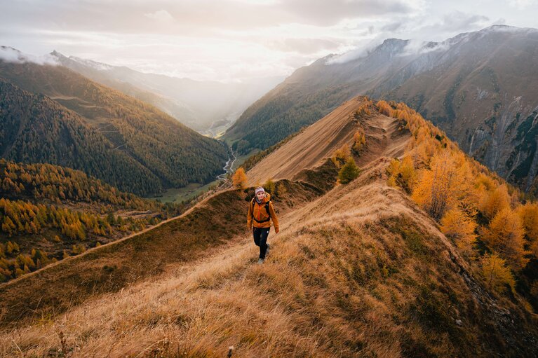 Eine Wanderin wandert entlang des Bergkamms im Bergsteigerdorf Schmirn | © TVB Wipptal / Johannes Bitter