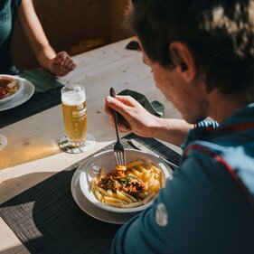 Een man is pasta met saus op een hut | © TVB Wipptal / Johannes Bitter