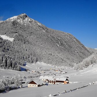 Verschneite Talansicht mit Häusern in Vals | © Steckholzer